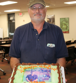 Jacque holding the cake from his farewell party. 