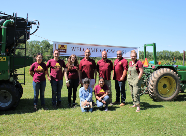 Program members posing in front of a welcome growers banner.