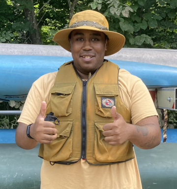 Kane in a life jacket and hat giving a double thumbs up. 